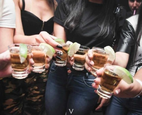 adults holding shots four females
